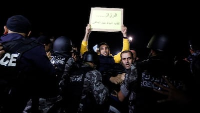 Demonstrators take part in a protest against tax hikes in Amman, Jordan November 30, 2018. The sign reads 'al-Razzaz is liar more than al-Mulqi'. Reuters
