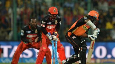 Royal Challengers Bangalore wicketkeeper Kedar Jadhav (C) and Chris Gayle look on as Sunrisers Hyderabad batsman Shikhar Dhawan (R) is bowled by RCB bowler Pervez Rasool during the 2016 Indian Premier League(IPL) Twenty20 cricket match between Royal Challengers Bangalore and Sunrisers Hyderabad at The M Chinnaswamy Stadium in Bangalore on April 12, 2016. AFP / MANJUNATH KIRAN