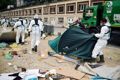 Workers clean up a migrants' makeshift camp along the Canal de Saint-Martin at Quai de Valmy in Paris, following its evacuation on June 4, 2018. More than 500 migrants and refugees were evacuated on early Monday from a makeshift camp that had been set up for several weeks along the Canal. Lucas Barioulet / AFP