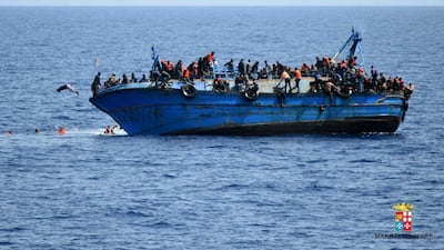 Refugees flee a boat in the Mediterranean just before it capsizes. Italian navy via AP