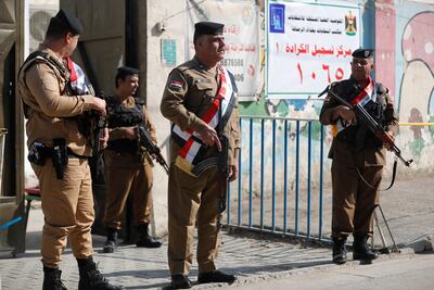 Armed police stand guard outside a polling station in the district of Karrada in Baghdad. AFP