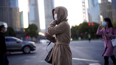 People wear protective face masks following an outbreak of the novel coronavirus disease at Lujiazui financial district in Shanghai, China March 19, 2020. REUTERS