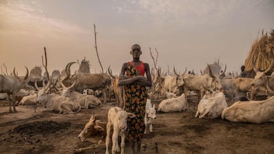 Sudanese girl Den, 14, from the Dinka tribe, works as a cattle keeper, cook and cleaner and aid to her brother.