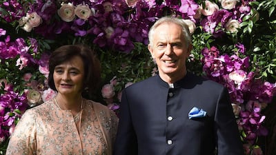Former British prime minister Tony Blair (R) and his wife Cherie Blair (L) pose for photographs as they arrive to attend the wedding ceremony of Akash Ambani. Photo: AFP