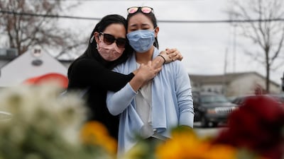 Helen Park Truong, 34, and Sarah Tang, 31, embrace after laying flowers at a makeshift memorial outside the Gold Spa, following the deadly shootings in Atlanta, Georgia, US. Reuters