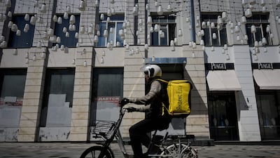 A food delivery courier passes a commercial premises put up for rent in Moscow. A series of punitive measures have been imposed by western countries to incapacitate Russia economically. AFP