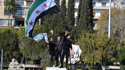 Syrians celebrating the fall of Bashar Al Assad wave the flag representing the opposition. AFP