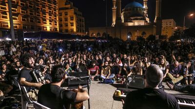 Lebanese protesters sit on the ground as they listen to the Lebanese Band 'Al-Rahel' during ongoing anti-government protests in downtown Beirut. EPA