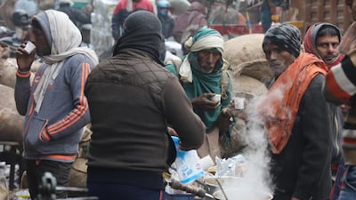 epa08095597 People line up at a tea stall on a cold morning in New Delhi, India, 31 December 2019. Northern India remains in the grip of cold as minimum temperature in the national capital New Delhi dropped below the three degrees Celsius mark. EPA/RAJAT GUPTA