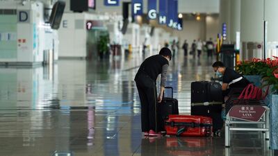 A woman, wearing a face mask as protection against the coronavirus, sorts luggage at Hong Kong International Airport in Hong Kong, China. Reuters