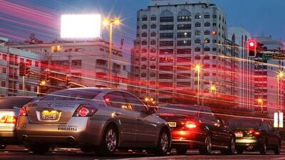 An electric sign overlooks the busy intersection at Airport Road and Al Falah Street.