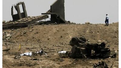 Rescuers walk among debris and bodies covered by sheets around the Evangelos Florakis naval base in Cyprus yesterday after a huge explosion involving cionfiscated armaments believed to have been heading from Iran to Syria, and destined for Gaza. Philippos Christou / AP Photo