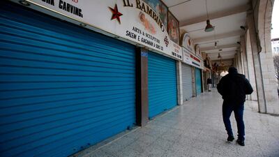 A Palestinian man walks past closed shops in the West Bank city of Bethlehem on March 6, 2020. AFP