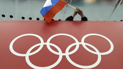 A Russian skating fan holds the country's national flag over the Olympic rings. David Phillip / AP