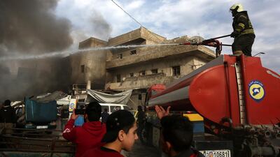 Firefighters try to extinguish flames at the site of airstrike targeting the centre in the industrial area in the east of Idlib. EPA