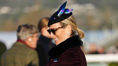 Zara Tindall, wearing a burgundy coat and navy hat, attends Cheltenham Racecourse on January 29, 2022. PA Wire