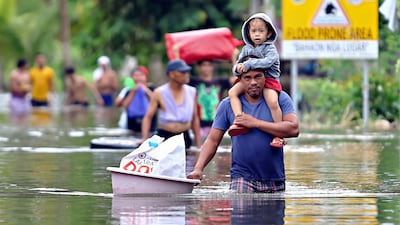 Residents leave their flooded homes due to heavy rain brought by the typhoon on the southern island of Mindanao. AFP