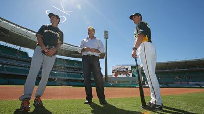Australian Baseball player Craig Anderson, left, and coaches Jon Deeble and Glenn Williams, right, inspect the baseball field at the Sydney Cricket Ground. Rick Rycroft / AP
