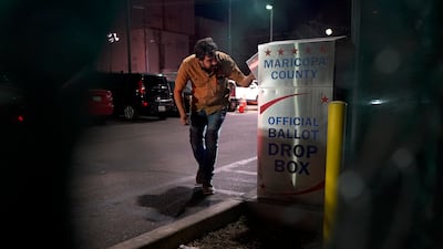 A voter drops off their ballot. AP