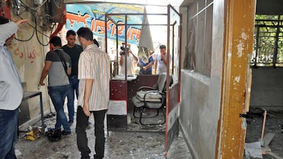The photo, released by SANA, shows people gathered at the scene of a suicide attack, in Hama, Syria, on Thursday, July 6, 2017. (SANA via AP)