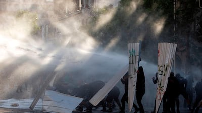 Demonstrators are sprayed with water cannons during clashes with riot police. AFP