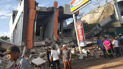 People survey the damage after dozens of buildings collapsed following a 6.4 magnitude earthquake in Ule Glee, Pidie Jaya in the northern province of Aceh, Indonesia on December 7, 2016. Nunu Husien / Reuters
