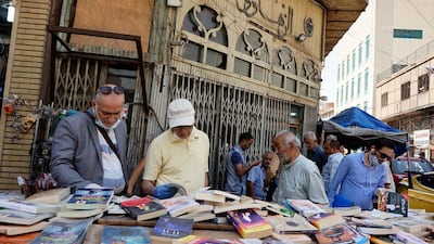 Iraqis check out books sold by a vendor in central Baghdad, April 22, during the coronavirus pandemic. Sabah Arar/ AFP