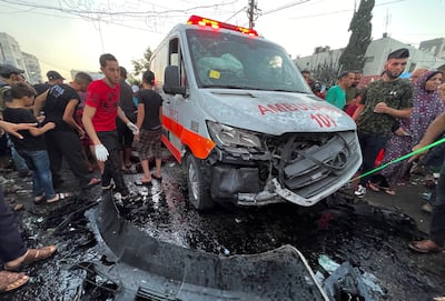 Palestinians inspect a damaged vehicle after a convoy of ambulances was hit outside Al Shifa Hospital in Gaza city. Reuters