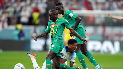England's Jude Bellingham is challenged by Senegal's Youssouf Sabaly. PA