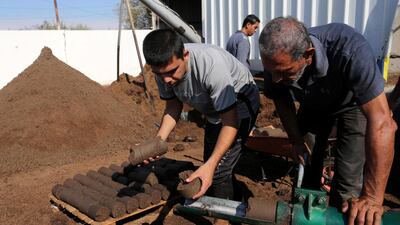 The team uses a specially-designed machine to produce green cakes of fuel. Muhammad Shehada / The National