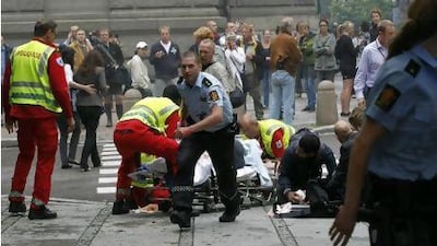 Rescue officials tend to a wounded man after a powerful explosion rocked central Oslo on 22.