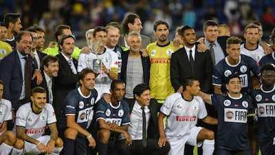 Argentinian defender Javer Zanetti, centre, in white, holds the trophy from the “Match For Peace” at the game’s finish on September 1, 2014 at Rome’s Olympic Stadium. Andreas Solaro / AFP