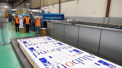 Above, workers making Alubond sheets at the Mulk Holdings facility in Sharjah. Pawan Singh / The National