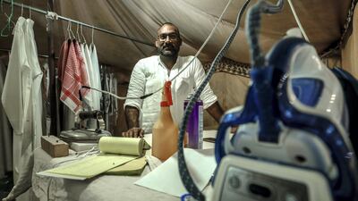 Etisham Ahmed presses 50 kandoras a day at a branch of Red Robe Laundry at the Al Dhafra Festival. Abu Dhabi, United Arab Emirates, December 10, 2019. Victor Besa / The National
