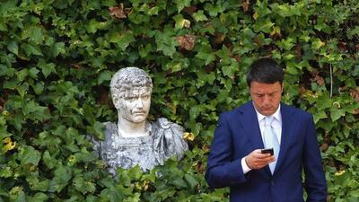 Italian Prime Minister Matteo Renzi uses his mobile phone as he waits for the arrival of European Commission President Jose Manuel Barroso before a meeting at Villa Madama in Rome. Remo Casilli / Reuters