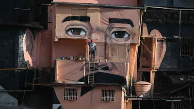 A mural celebrating Venezuelan doctor Jose Gregorio Hernandez, known as the Doctor of the Poor, is painted across houses in the El Saman de Bolívar community, in the Petare neighbourhood of Caracas. AFP
