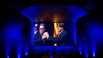 A screen shows former Catalonia regional government president and chairman of the Catalan nationalist party, Artur Mas (L), and former Catalan regional president Carles Puigdemont (R). EPA-EFE/QUIQUE GARCIA