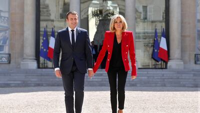 France's President Emmanuel Macron and his wife Brigitte, walk toward the Elysee Palace courtyard to welcome autistic people attending the launching of a programme to enhance the diagnosis and treatment of autism, a cause dear to the French first lady, on July 6, 2017. Thibault Camus / AP Photo