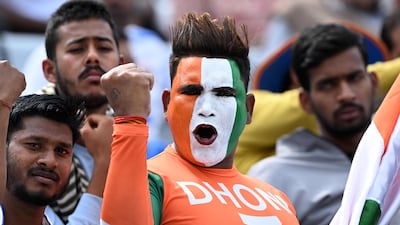 An Indian cricket fan with his face painted in the colours of the flag of India cheers from the stands. AFP