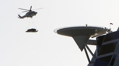 An Aston Martin car being lowered by helicopter into the helipad of the Burj Al Arab. Jaime Puebla / The National
