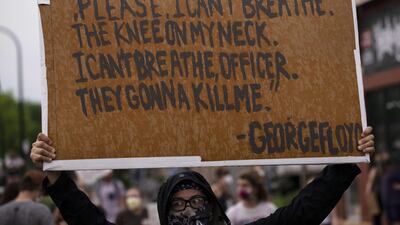A protester holds a sign while demonstrating against the death of George Floyd outside the 3rd Precinct Police Precinct in Minneapolis, Minnesota. AFP