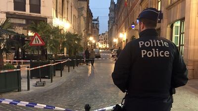 A police officer stands behind a police tape during investigations at a stabbing scene in the center of Brussels, Tuesday, Nov. 20, 2018. AP