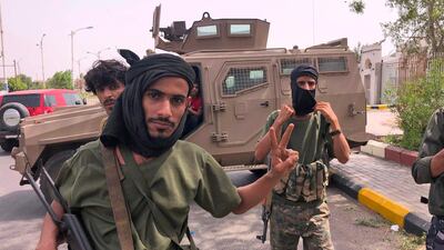 Fighters of the UAE-trained Security Belt Force of the Southern Transitional Council pose for a picture while standing before an armoured vehicle in Khor Maksar in the centre of Yemen's second city of Aden. AFP