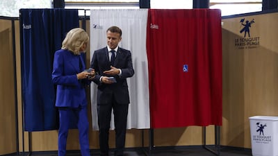 Mr Macron and his wife Brigitte exit a polling booth. AFP