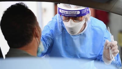 Health workers wearing overalls and protective masks perform swab tests in Rome on Monday. EPA