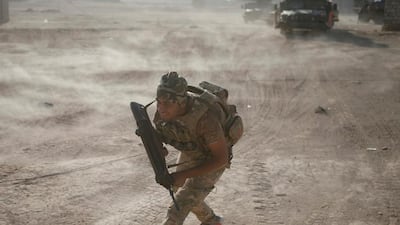 A member of Iraqi special forces runs for cover. Goran Tomasevic / Reuters