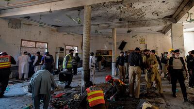 Security officials examine the site of a blast at a religious school in Peshawar. AFP