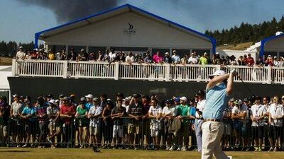 Smoke from a near-by fire rises over the course as Branden Grace hits his tee shot on the tenth hole. Erik S Lesser / EPA / June 20, 2015
