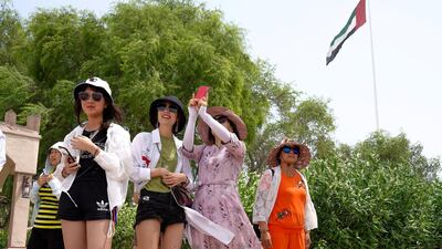 Chinese tourists enjoy the sights at the Heritage Village, Corniche, in spite of the humid weather. Victor Besa / The National