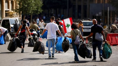 Lebanese activists clean a main road in downtown Beirut on October 19, 2019 as hundreds continued to gather in Lebanon for a third day of protests against tax increases and alleged official corruption after the security forces made dozens of arrests. AFP